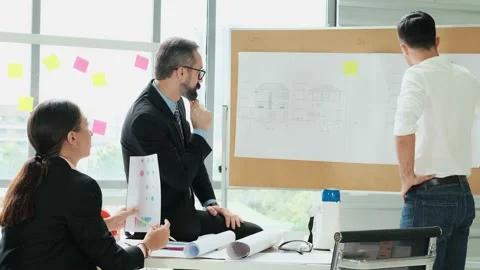A team of engineers and architects meets at Brainstorm to work and discuss pr Stock Footage 153670590