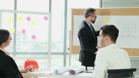 A team of engineers and architects meets at Brainstorm to work and discuss pr Stock Footage 153671384