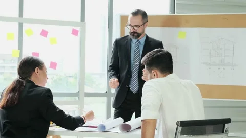 A team of engineers and architects meets at Brainstorm to work and discuss pr Stock Footage 153671551