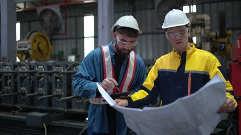 Team of engineers and architects working with blueprint at factory site. Stock Footage 254756293