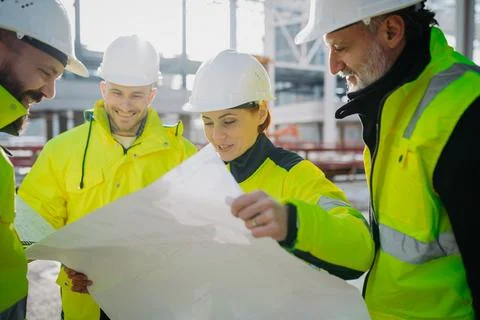 Team of engineers and construction workers inspecting building progress. Fotos de archivo