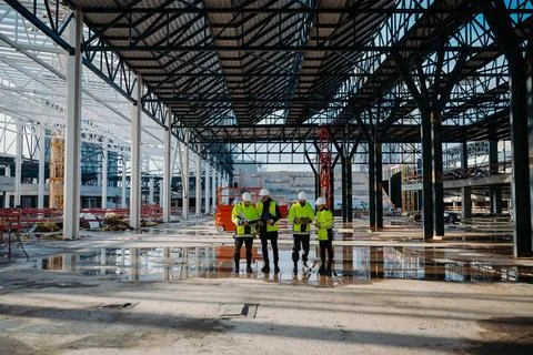 Team of engineers and construction workers inspecting building progress. Fotos de archivo
