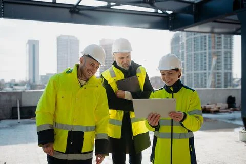Team of engineers and construction workers inspecting building progress. Fotos de archivo
