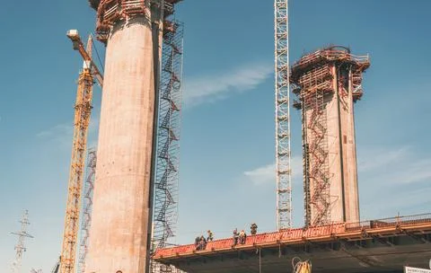 Team of engineers and laborers work on the platform of a bridge construction  Stock Photos