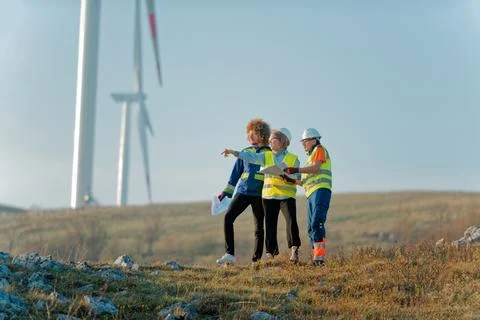 A team of engineers and workers oversees a wind Foto stock