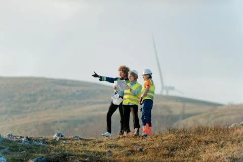 A team of engineers and workers oversees a wind Foto stock