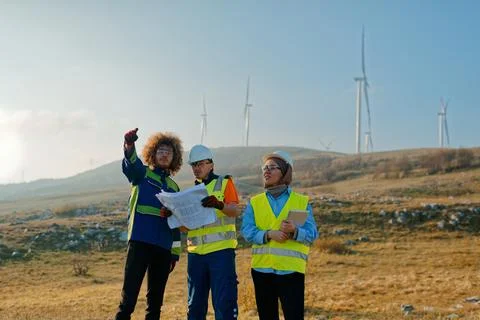 A team of engineers and workers oversees a wind Foto stock