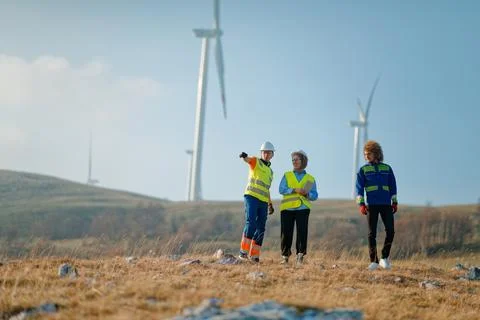 A team of engineers and workers oversees a wind Foto stock