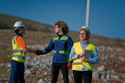 A team of engineers and workers oversees a wind Foto stock