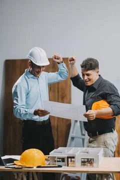 Team Engineers with draft plan of building on constructing site. Engineer w.. Fotos de archivo