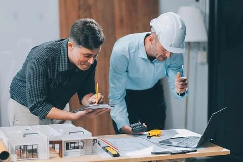 Team Engineers with draft plan of building on constructing site. Engineer w.. Fotos de archivo