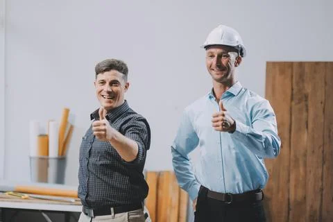 Team Engineers with draft plan of building on constructing site. Engineer w.. Fotos de archivo