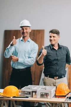 Team Engineers with draft plan of building on constructing site. Engineer w.. Fotos de archivo