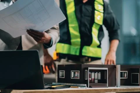 Team Engineers with draft plan of building on constructing site. Engineer w.. Fotos de archivo
