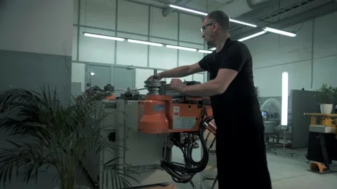 Team of engineers in the factory work at a CNC machine that bends metal products Stock Footage 179700201