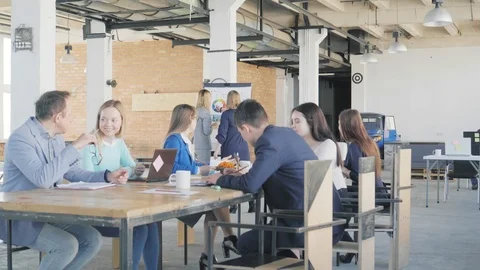 A team of engineers holds a meeting at a large table. In the background, two Stock Footage 109507429