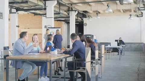 A team of engineers holds a meeting at a large table. In the background, the Stock Footage 109555075