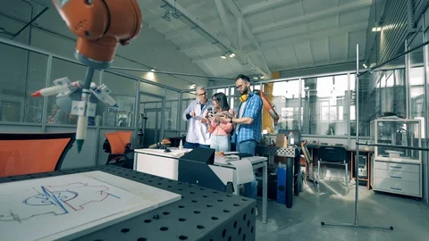 Team of engineers in a laboratory with functioning robots Stock Footage 128419264