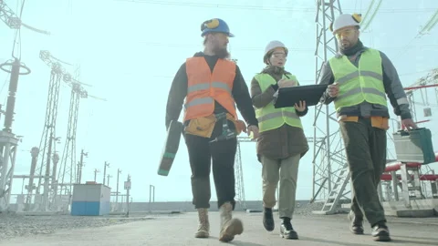 A team of engineers walk through a high voltage substation Stock Footage 142767677
