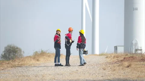 Team of engineers working on wind turbines in a wind farm Stock Footage 264134258