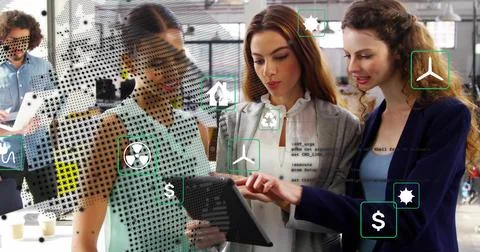 Team examining tablet in office featuring green icons, money icons, code icons, Stock Photos