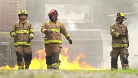 A team of firefighter in full protective gear runs through intense flames while Vídeos de archivo 326217498