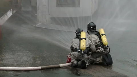 A team of firefighters using high pressure hoses Stock-Footage 85715681
