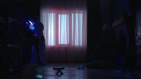 A team of forensic specialists work at the crime scene, in a dark apartment lit Stock-Footage 249261201