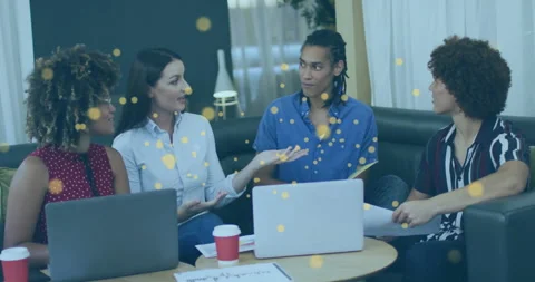 Team of four discussing crypto in lounge while golden particles drifting into Stock Footage 311963603