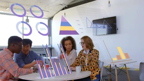 Team of four leaning at laptop, man pointing and starting data charts overlaying Stock Footage 333287845