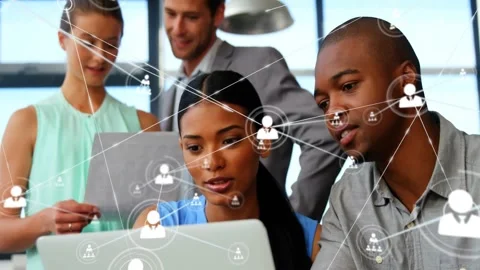 Team of four leaning over laptop, circular icon appearing, spawning network map Stock Footage 334184908
