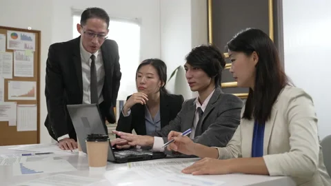 Team of four looking laptop brainstorming ideas Video stock 211666211