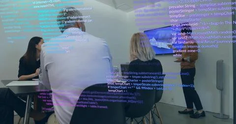 Team of four reviewing software code on mounted screens in modern meeting room, Foto stock