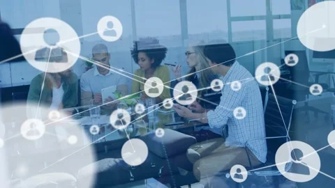 Team gesturing at glass table, initiating icon network expanding over devices, Stock Footage 333963130