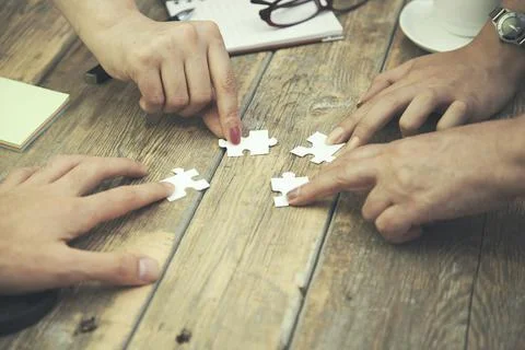 Team hands on puzzles Stock Photos