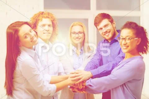 Team with hands on top of each other in office Stock Photos