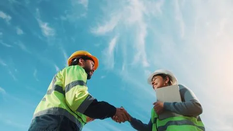 Team, handshake and happy people with tablet on construction site, low angl.. Stock Photos