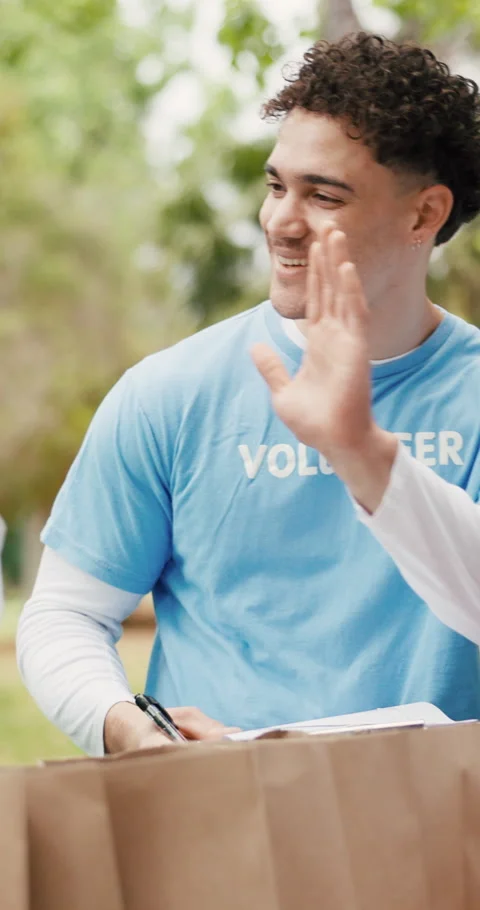 Team, high five and volunteer with man in park for outreach program, food drive Stock Footage 321929266