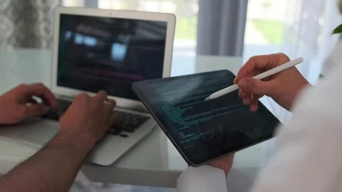 Team improves the app, fixing code on a laptop. Stock Footage 294298832