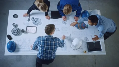 Team of Industrial Engineers Lean on Office Table, Analyze Machinery Blueprints Stock Footage 124060901