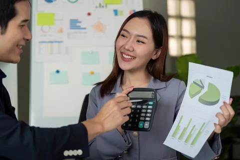 Team Interaction and Problem Solving. Colleagues discussing financial data while Stock Photos