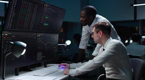 Team of it programmers working on desktop computers in data center control room Stock-Fotos
