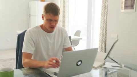 Team lead codes and video calls from a minimalist apartment. 스톡 동영상 296222853