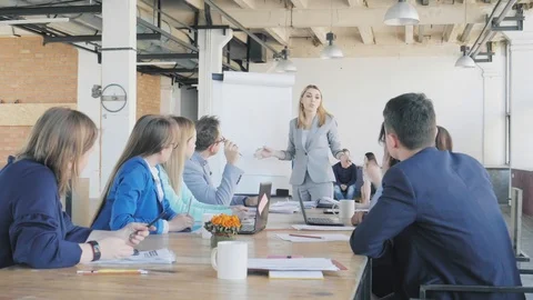 The team leader conducts a presentation on a flipchart and describes business Stock Footage 109570301