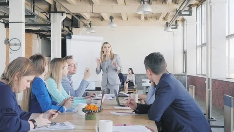 The team leader conducts a presentation using a flipchart, describes business Stock Footage 111584703