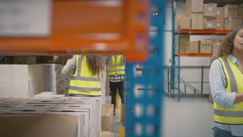 Team Leader With Digital Tablet In Busy Warehouse Training Female Intern Stock Footage 179669073