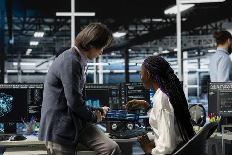 Team leader helping intern in data center to use AI LLM assistant Stock Photos