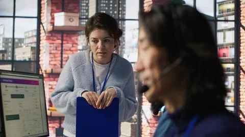 Team leader overseeing work done by call center agent tracking shipments Stock Photos