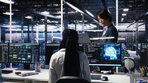 Team leader supervising technicians in server room using AI Stockfoto's