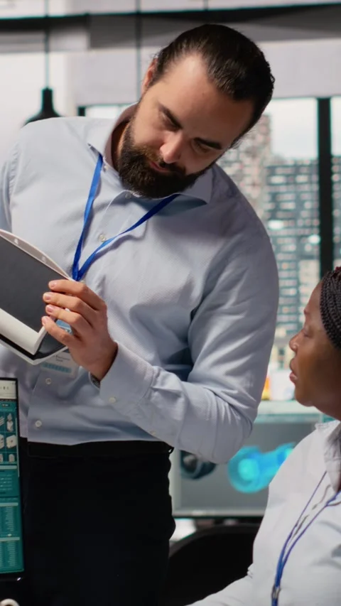 Team leader supervising work done by engineer creating solar cell energy device Stock Footage 315416546